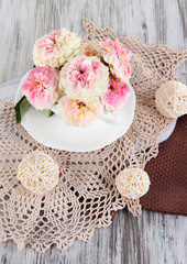 Roses in cup on napkins on  wooden background