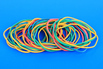 Colorful rubber bands on blue background