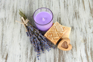 Lavender candle with fresh lavender, soap on wooden background