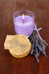 Fototapeta na wymiar Lavender candle with fresh lavender, soap on wooden background