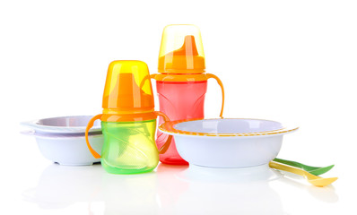 Bright baby bottles, bowls and spoons isolated on white