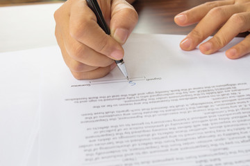 Female hand signing contract.