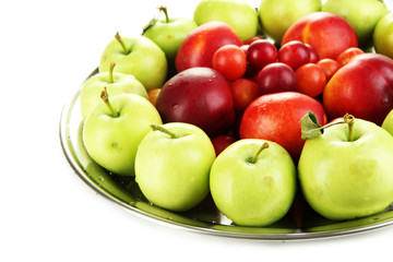 Assortment of juicy fruits on plate, isolated on white
