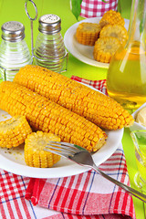 Flavored boiled corn on  plate on wooden table close-up