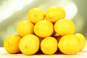 Ripe lemons on table on bright background