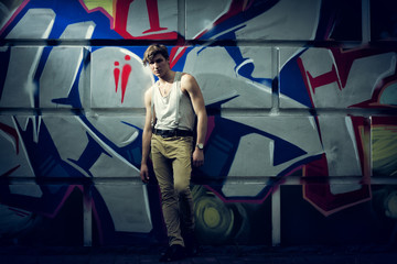 stylized image of the fashion guy against a wall with graffiti