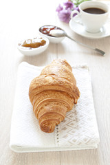 Croissants on table with jam and coffee