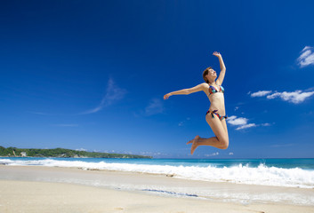 Fototapeta na wymiar Woman jumping on the beach