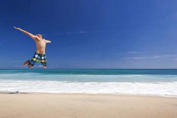 Fototapeta na wymiar Man jumping on the beach