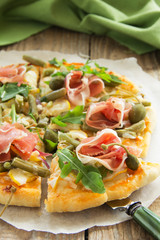 Pizza with arugula and prosciutto.