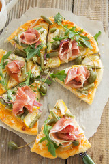 Pizza with arugula and prosciutto.