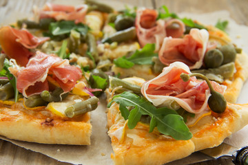 Pizza with arugula and prosciutto.