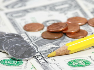 yellow pencil and coin on bill