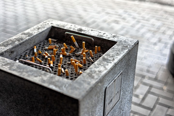 Cigarettes in a public ashtray