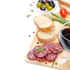 salami, ciabatta, olives and a glass of wine on a wooden board