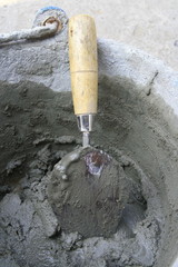 construction trowel and wet concrete