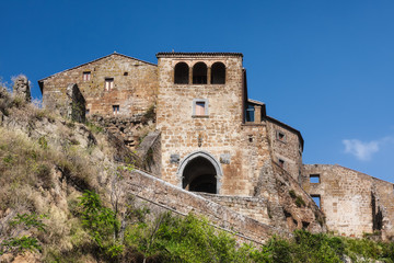 Fototapeta premium Porta Santa Maria gothic gateway and medieval tower of Civita di Bagnoregio on a tuff cliff, Lazio, Italy