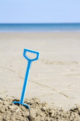 Fototapeta na wymiar Plastic spade on sandy beach