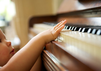 Portrait of a baby playing the piano © mimagephotos