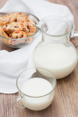 Milk with biscotti on wooden board