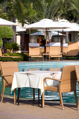 Fototapeta na wymiar Table and chairs next to the pool, Thailand