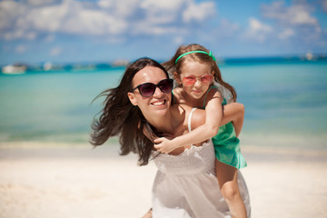 Young beautiful mother and her adorable little daughter have fun