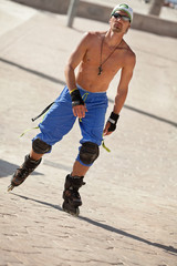 junger erwachsener mann im sommer mit rollerblades inlineskates
