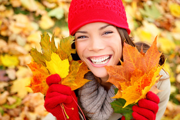 Autumn woman holding fall leaves in forest
