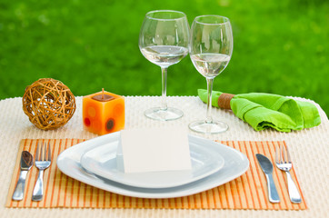 Empty classic white plate in a restaurant with blank card and