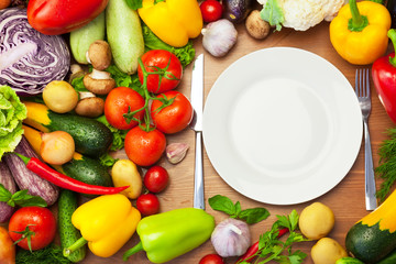 Fresh Organic Vegetables Around White Plate with Knife and Fork