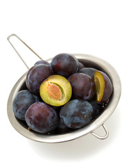 plums in metallic colander
