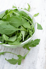 rucola in a glass bowl isolated on white background