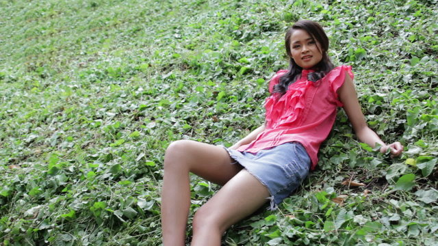 Sexy erotic asian girl with mini skirt on green grass