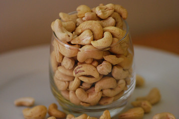Cashewnuts in a glass on a white plate