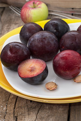 Ripe plums on a wooden background