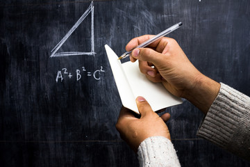 Man taking notes of math theorem on blackboard - Powered by Adobe