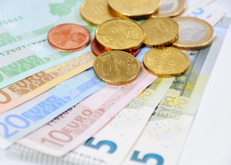 Euroscheine und Münzen mit weißem Hintergrund