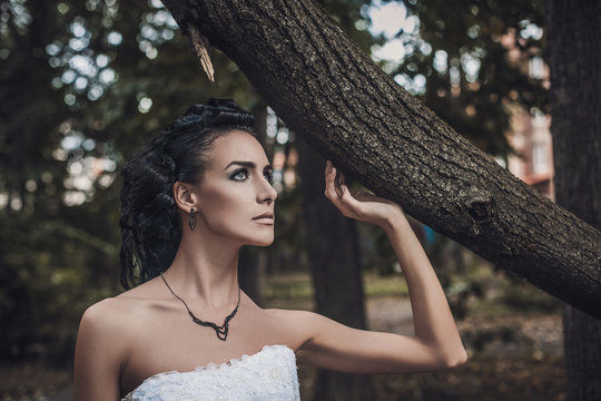 Beautiful wedding style brunette bride woman in wood park