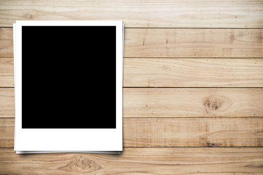 blank photo frame on brown wood plank background