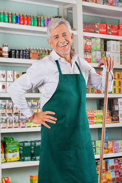 Senior Male Owner Standing Against Shelves In Store
