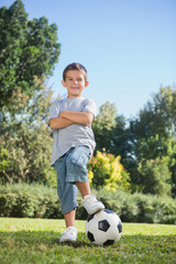 Young boy posing with football