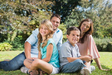 Fototapeta na wymiar Young family sitting in a park