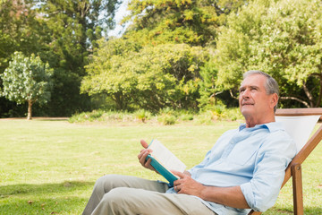 Fototapeta premium Smiling mature man holding a book