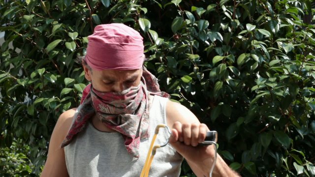 masked man with sling