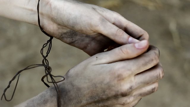 Chained woman with piece of bread on the field.