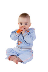 Smiling baby eats carrot