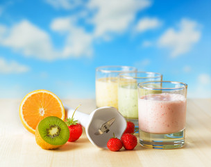 Fruit smoothie on wooden table on blue sky