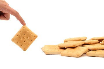 Hand holds saltine soda cracker.