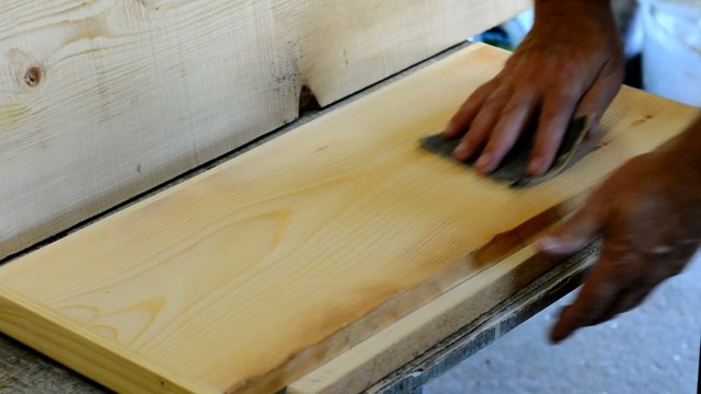 Worker uses the emery paper to grind the wood.