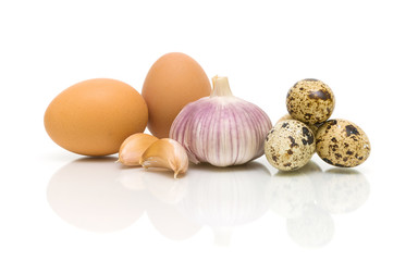 chicken eggs, garlic and quail eggs on a white background